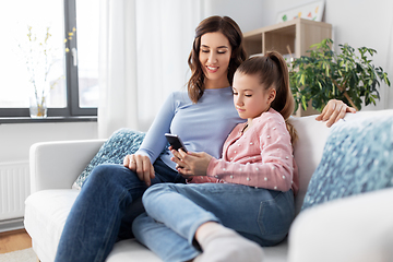 Image showing happy mother and daughter with smartphone at home