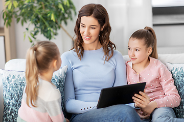 Image showing happy mother and daughters with tablet pc at home