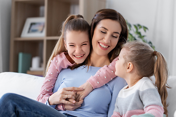 Image showing happy smiling mother with two daughters at home