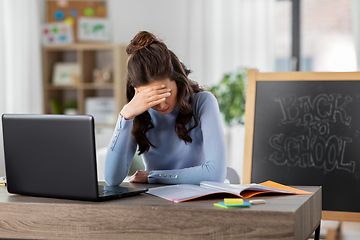 Image showing teacher with laptop and notebook working from home