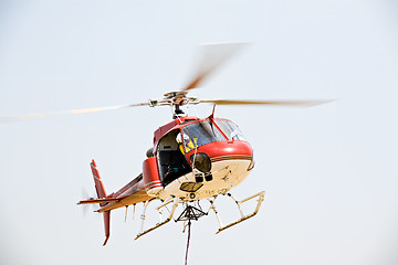 Image showing helicopter picking up cargo