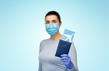 Image showing young woman in mask with air ticket and passport