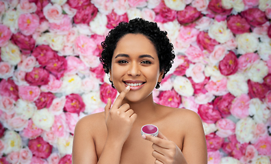 Image showing african american woman applying lip gloss