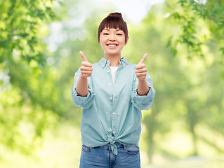 Image showing happy asian woman showing thumbs up over white