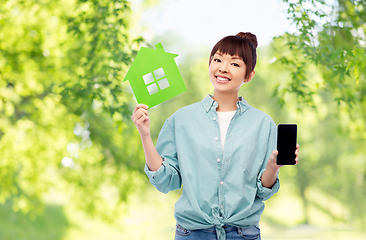 Image showing smiling asian woman holding green house