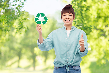 Image showing smiling asian woman holding green recycling sign