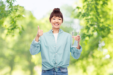 Image showing happy asian woman holding glass bottle with water