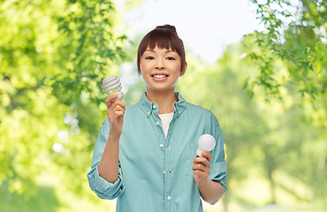 Image showing asian woman holding energy saving lighting bulb