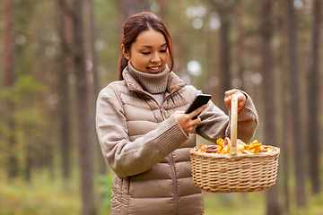 Image showing asian woman using smartphone to identify mushroom