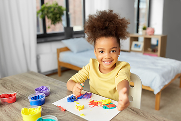 Image showing little girl with modeling clay playing at home