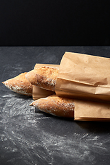 Image showing close up of baguette bread in paper bags on table