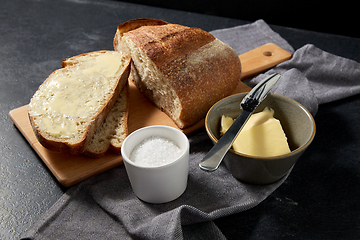 Image showing close up of bread, butter, knife and salt on towel