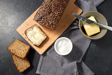 Image showing close up of bread, butter, knife and salt on towel