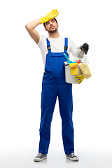 Image showing tired male cleaner with cleaning supplies