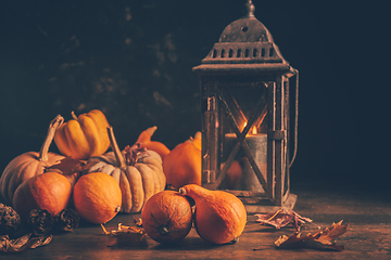 Image showing Assortment of pumpkins with autumn leaves on wooden background