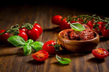 Image showing Sun dried and pickled tomatoes with fresh herbs and spices