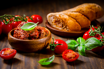 Image showing Sun dried and pickled tomatoes with fresh herbs and spices