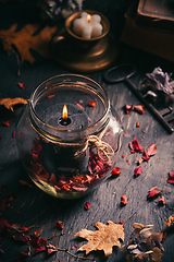 Image showing Fall candle decoration with dried leaves, autumn wooden home decor still life scented candle, autumn season interior decoration details