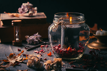 Image showing Fall candle decoration with dried leaves, autumn wooden home decor still life scented candle, autumn season interior decoration details