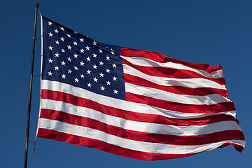 Image showing American Flag Waving In Wind Against a Deep Blue Sky