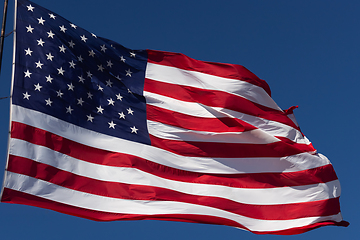 Image showing American Flag Waving In Wind Against a Deep Blue Sky