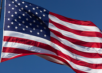 Image showing American Flag Waving In Wind Against a Deep Blue Sky