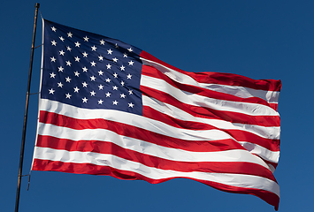 Image showing American Flag Waving In Wind Against a Deep Blue Sky