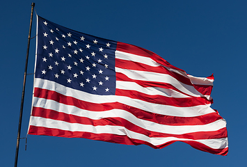 Image showing American Flag Waving In Wind Against a Deep Blue Sky