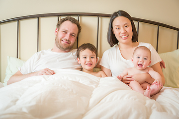 Image showing Mixed Race Chinese and Caucasian Baby Boys Laying In Bed with Th