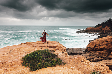 Image showing Brave female faces the dark storm by the ocean