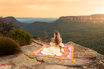 Image showing Woman on rug on mountain cliff with vsplendid iews