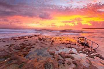 Image showing Ocean and rock pool overflow with amazing sunrise sky