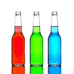 Image showing bottles red green and blue with reflection isolated on white