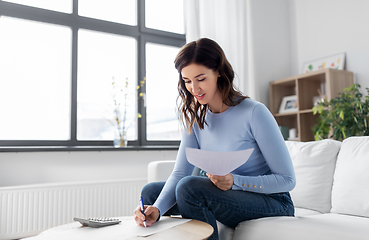 Image showing woman with papers and calculator at home