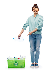 Image showing smiling young asian woman sorting plastic waste