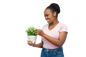 Image showing happy smiling african woman holding flower in pot