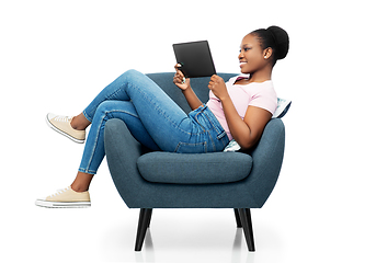 Image showing smiling woman with tablet pc sitting in armchair