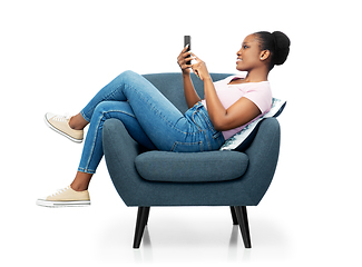 Image showing african american woman with smartphone in armchair