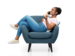 Image showing african woman calling on smartphone in armchair