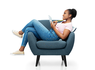 Image showing happy young woman in armchair writing to notebook