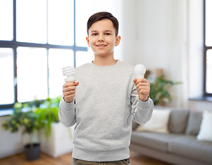 Image showing smiling boy comparing different light bulbs