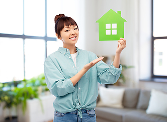 Image showing smiling asian woman holding green house