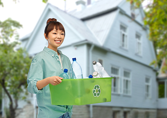 Image showing smiling young asian woman sorting plastic waste