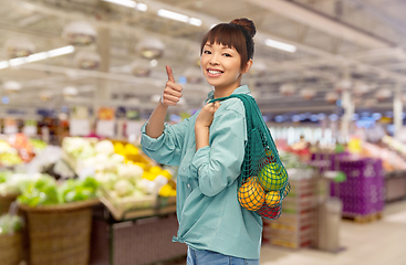 Image showing happy asian woman with food in reusable string bag