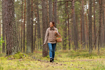 Image showing young woman picking mushrooms in autumn forest