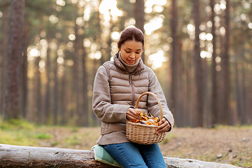 Image showing woman with mushrooms in basket in autumn forest