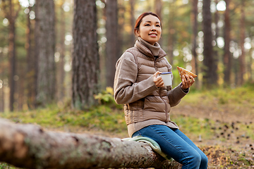 Image showing woman drinking tea and eating sandwich in forest