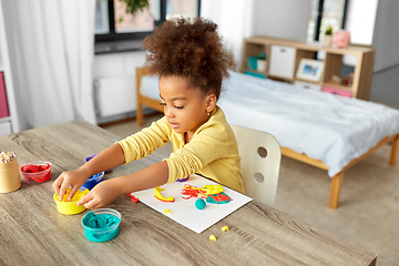 Image showing little girl with modeling clay playing at home