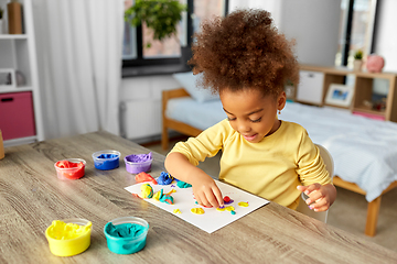 Image showing little girl with modeling clay playing at home