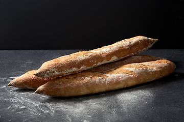 Image showing baguette bread on table over dark background